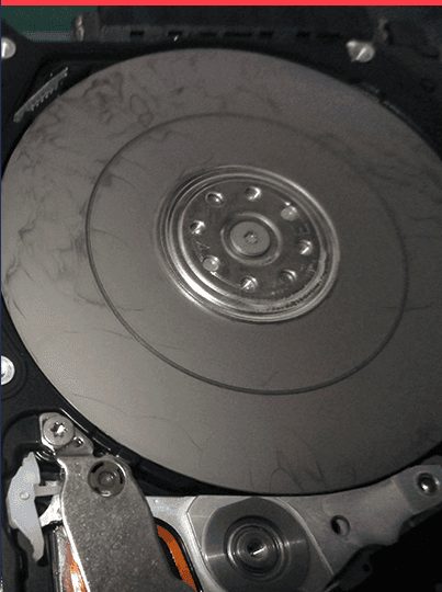 Disque dur ouvert en salle blanche montrant la disposition des plateaux et bras de lecture